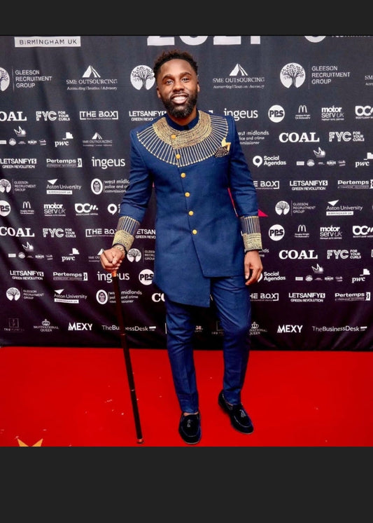 an African American star wearing a stylishly embroidered black panther inspired men's suit, smiling and feeling good about his good looks.