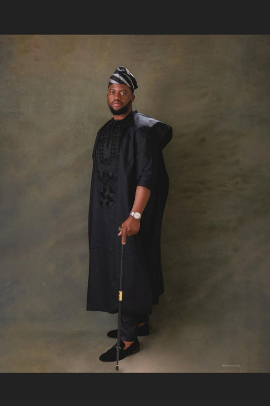 an African man wearing a black three piece suit for African wedding