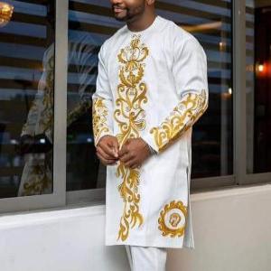 well-groomed African man wearing a white luxury embroidered wedding kaftan. feeling handsome and bold. outfit sold by finessestitches.com